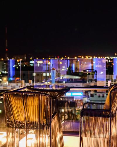 a view of a city at night from a balcony at Hotel Agnes in Buriram