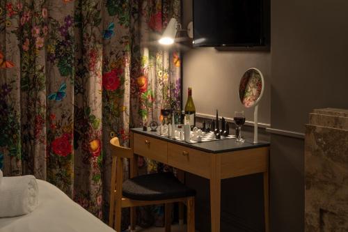 um quarto com uma mesa com copos de vinho em The Goodenough Hotel London em Londres