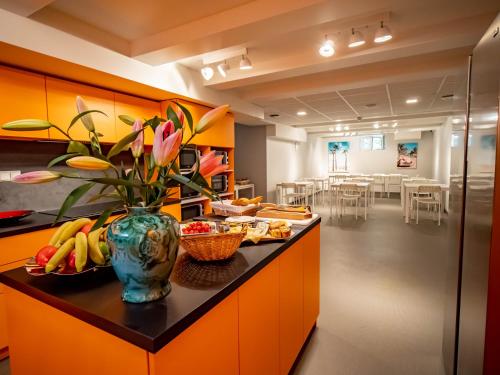 eine Küche mit orangefarbenen Schränken und einer Vase aus Blumen in der Unterkunft BANANA'S CAMP in Cannes