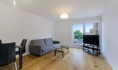 sala de estar con sofá y TV en City Riverview 1/2 Bedroom Apartment en Londres