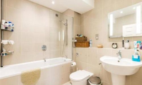 y baño con lavabo, bañera y aseo. en City Riverview 1/2 Bedroom Apartment en Londres