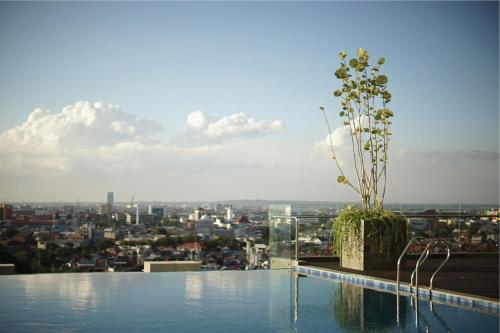 a swimming pool with a view of a city at Platinum Hotel Tunjungan Surabaya in Surabaya