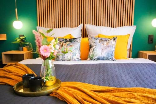a bed with a tray with a vase of flowers on it at Alex & Rine - Pension Zum Alten Strom in Warnemünde