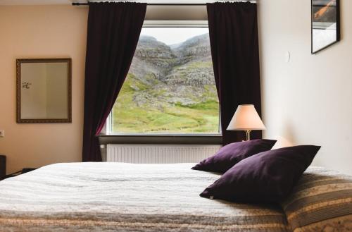 um quarto com uma cama e uma grande janela em Hotel Latrabjarg em Hnjótur