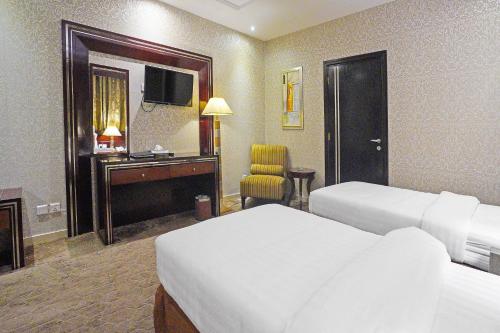 a hotel room with two beds and a television at Ekono Hotel in Jeddah