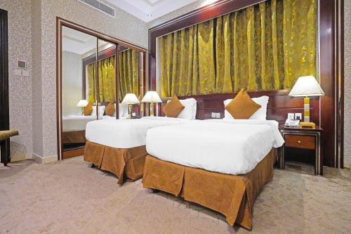 um grande quarto de hotel com duas camas e uma grande janela em EKONO by Leva Jeddah Airport Hotel em Jeddah