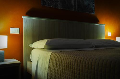 a bedroom with a large bed with an orange wall at La casa di Bice in Cassibile