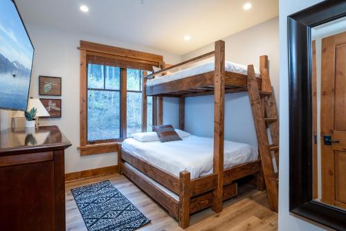 a bedroom with two bunk beds and a desk at NEW LISTING! Luxury Northstar Village Residence - Big Horn 210 in Truckee