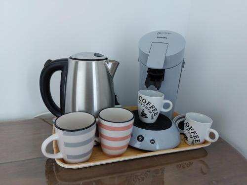 a coffee maker and coffee cups on a tray at Chambre d’hôte Chancelier Guerin in Mont-lʼEvêque