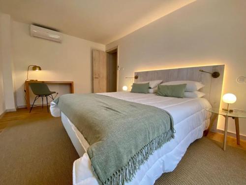 a bedroom with a large white bed in a room at Nature & Sea - Casa da Vinhateira South in Caloura