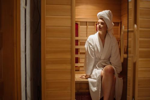 a woman sitting in a sauna with a towel on her head at Курортний Готель Золота Корона in Truskavets