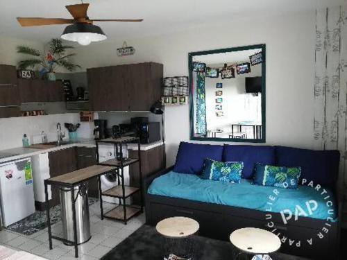 un salon avec un canapé bleu et une cuisine dans l'établissement Au calme, 100m plage Écluse, balcon, box garage, Wifi, à Dinard