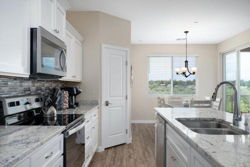 a kitchen with white cabinets and a sink at Stunning Views + Hot Tub + Location! 3 bed/3 bath in Cottonwood