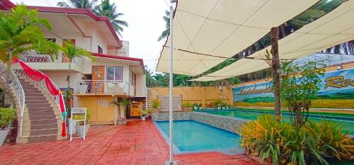 ein Resort mit einem Pool und einem Gebäude in der Unterkunft Ladolcevita Inland Resort in Cabadbaran