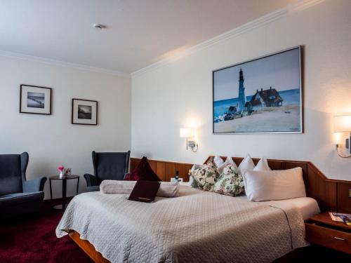 a hotel room with a bed and a lighthouse at Garni Hotel & Appartements Nordstrand in Nordstrand