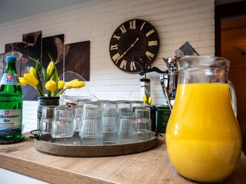 a counter with glasses and a jug of orange juice at Garni Hotel & Appartements Nordstrand in Nordstrand