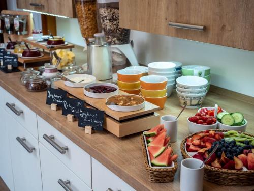 a buffet with fruits and other foods on a counter at Garni Hotel & Appartements Nordstrand in Nordstrand
