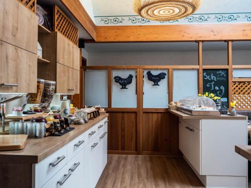 a kitchen with white counters and wooden cabinets at Garni Hotel & Appartements Nordstrand in Nordstrand