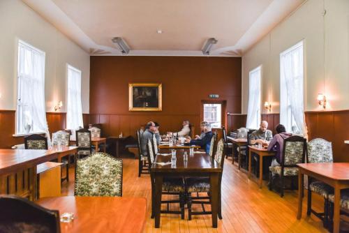 a group of people sitting at tables in a restaurant at Hotel Latrabjarg in Örlygshöfn