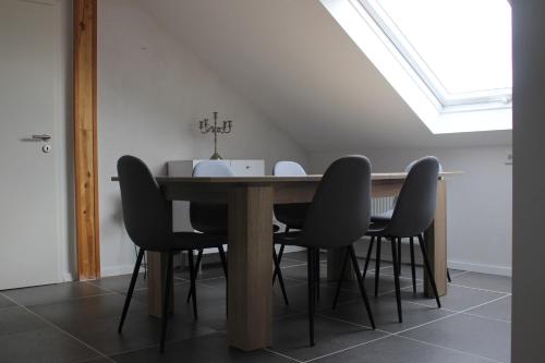 a dining room table with black chairs and a skylight at ALB-Wohnung - Schwäbische Alb in Heroldstatt
