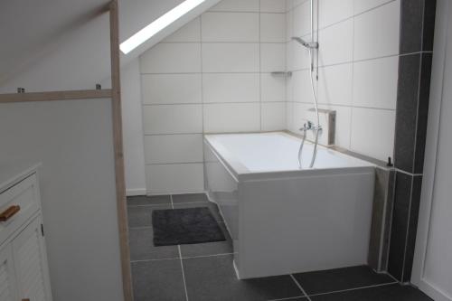 La salle de bains blanche est pourvue d'une baignoire et d'un lavabo. dans l'établissement ALB-Wohnung - Schwäbische Alb, à Heroldstatt