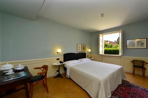 a bedroom with a bed and a table and a window at Hotel San Luca in Spoleto