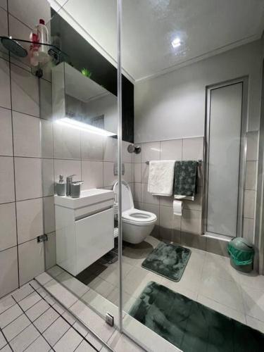 a bathroom with a shower and a sink and a toilet at 715 Foreshore Place Luxury Apartment-Cape Town CBD in Cape Town