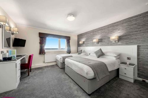 a hotel room with two beds and a desk at Viking Hotel - Adults Only in Blackpool