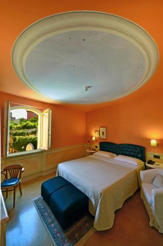 a bedroom with a large bed with an orange wall at Hotel San Luca in Spoleto