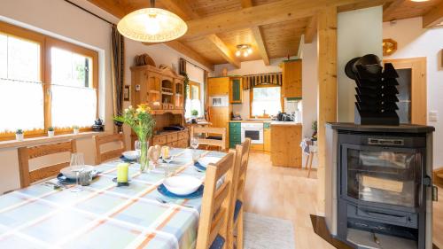 eine Küche und ein Esszimmer mit einem Tisch und einem Kamin in der Unterkunft Ferienhaus Rauscher in Sittersdorf