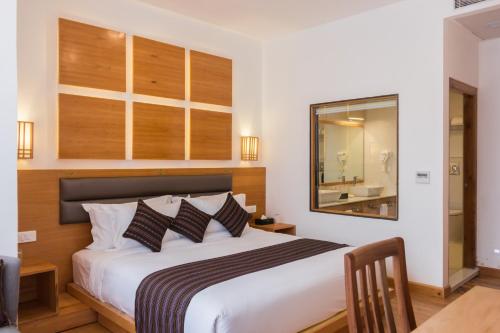 a bedroom with a large bed and a mirror at Pelyang Boutique in Thimphu