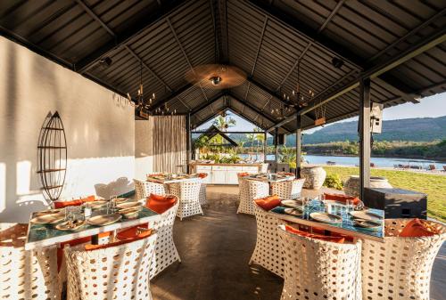 ein Restaurant mit Tischen und Stühlen und Aussicht in der Unterkunft Canary Islands Resort & Spa in Lonavla