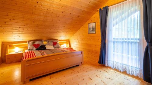um quarto com uma cama num quarto de madeira em Ferienhaus Rauscher em Sittersdorf