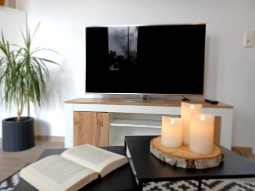 d'un salon avec une table avec des bougies et une télévision. dans l'établissement AMS Appartement Spaichingen, à Spaichingen