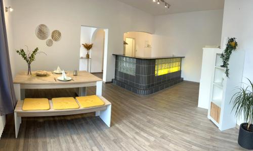 um quarto com uma mesa, um banco e uma lareira em AMS Appartement Spaichingen em Spaichingen