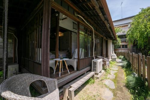 a porch of a house with chairs and a table at Villa Sacra ヴィラサクラ in Kamakura