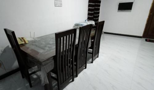 Serene Homestay في أنورادابورا: طاولة وكراسي في غرفة ذات أرضية بيضاء