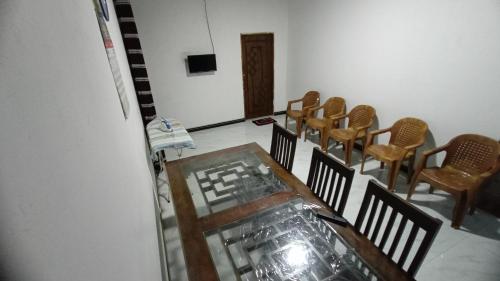 a group of chairs and a glass table in a room at Serene Homestay in Anuradhapura