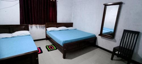 a room with two beds and a mirror at Serene Homestay in Anuradhapura