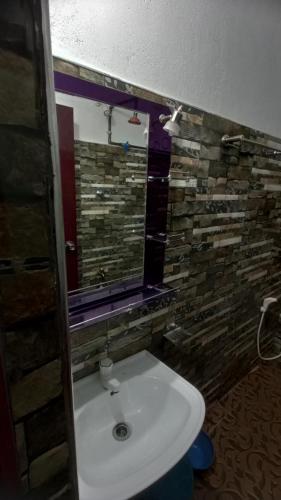 a bathroom with a white sink and a mirror at Serene Homestay in Anuradhapura