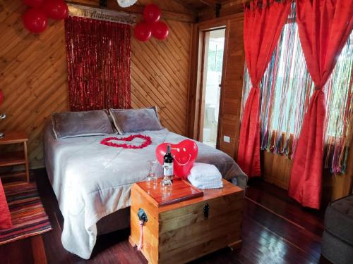 Un dormitorio con una cama decorada en rojo. en Zasqua Glamping, en El Cape