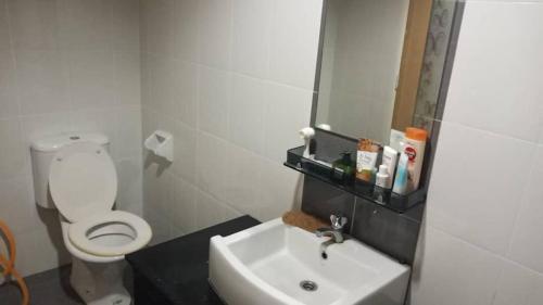 a bathroom with a white toilet and a sink at 7eVenKitchen Hmestay in Jitra