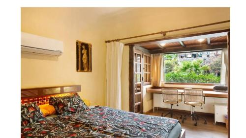 1 dormitorio con cama, mesa y ventana en VCV VILLA BAHÍA FELIZ, en Playa del Águila