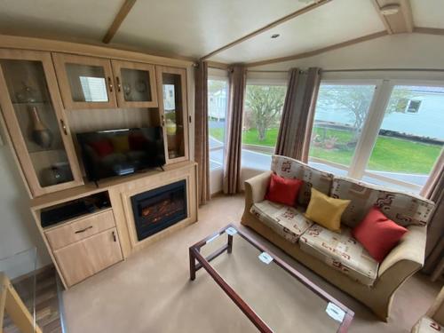 a living room with a couch and a fireplace at Lili-anns Retreat Cosy Holiday Home in Millom
