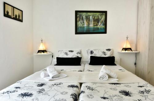 two twin beds in a room with two lamps at APP Laura with Common Pool in Nova Vas