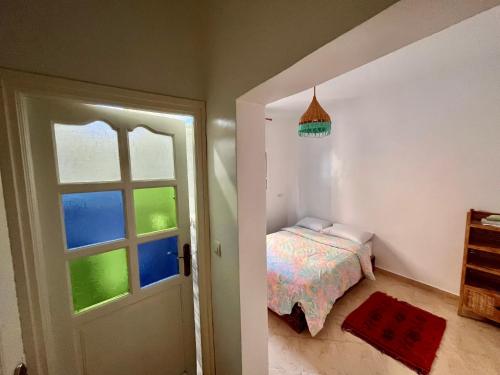 um pequeno quarto com uma cama e uma janela em Cozy Surf House em Taghazout