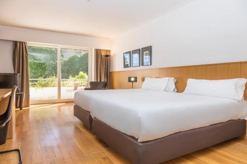 a large white bed in a hotel room at B&B HOTEL Sado Setúbal in Setúbal