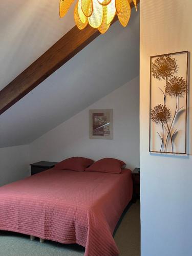une chambre avec un lit avec une couverture rouge dans l'établissement Le clos de la cote d'Emeraude, à Saint-Benoît-des-Ondes