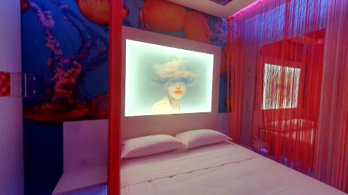 a room with a bed with a picture of a woman at C rooms - Love Motel Monza in Cinisello Balsamo