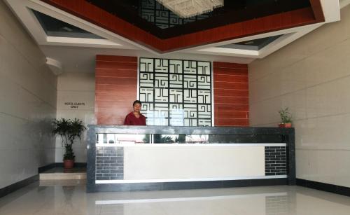 a woman standing behind a counter in a lobby at Emerald Hotel & Restaurant in Nuku‘alofa